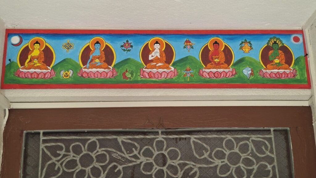 Painting of the Five Buddha Families above a household doorway in Patan, Nepal.